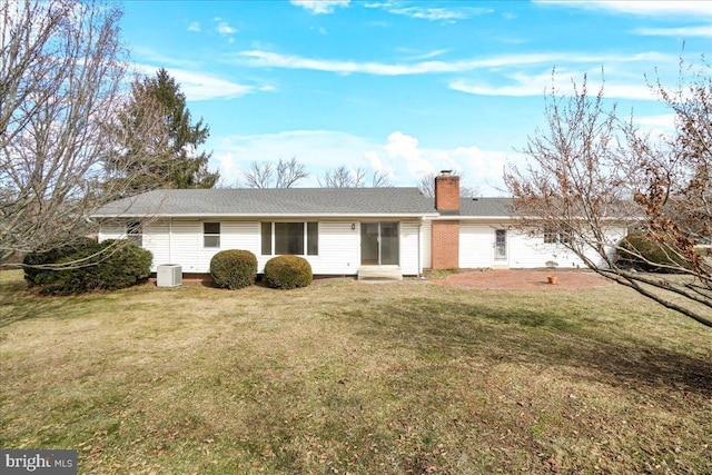 back of house with entry steps, a lawn, a chimney, and central air condition unit