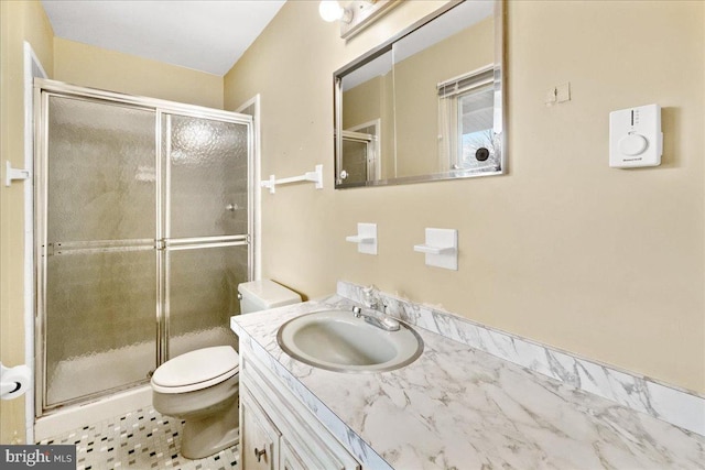 full bathroom featuring a stall shower, vanity, and toilet