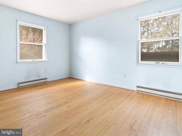 spare room featuring a baseboard heating unit, a baseboard radiator, and light wood-style flooring