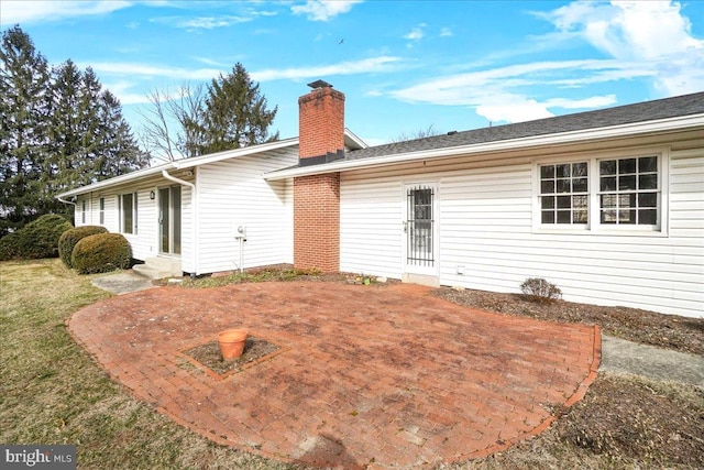 rear view of property featuring entry steps, a yard, and a chimney