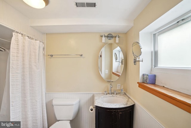 bathroom featuring walk in shower, vanity, and toilet