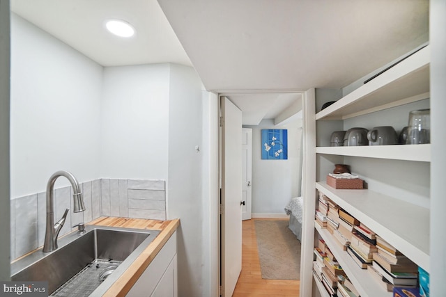 interior space featuring sink, white cabinets, and light hardwood / wood-style flooring