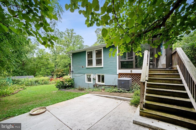 back of house with cooling unit, a yard, and a patio area