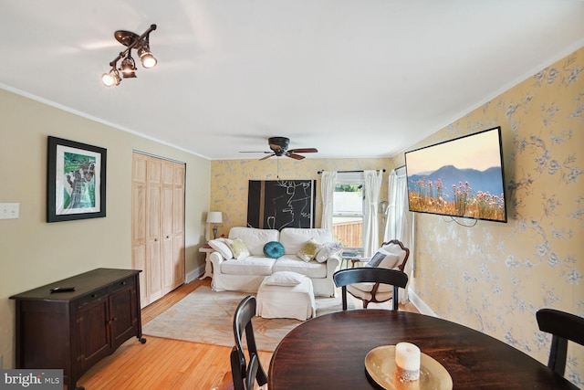 living room with crown molding, ceiling fan, and light hardwood / wood-style flooring