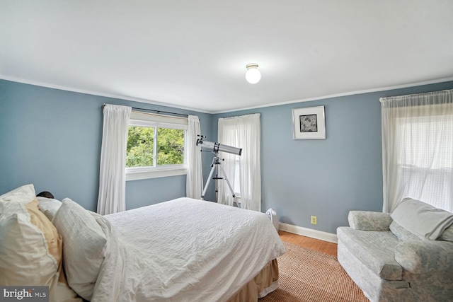 bedroom featuring ornamental molding and light hardwood / wood-style flooring