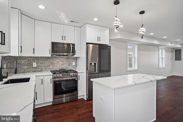 kitchen featuring white cabinetry, stainless steel appliances, and light stone counters