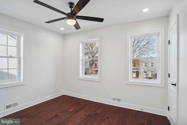 empty room with hardwood / wood-style flooring, ceiling fan, and plenty of natural light