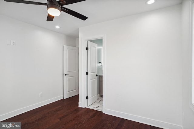 unfurnished bedroom with connected bathroom and dark hardwood / wood-style floors