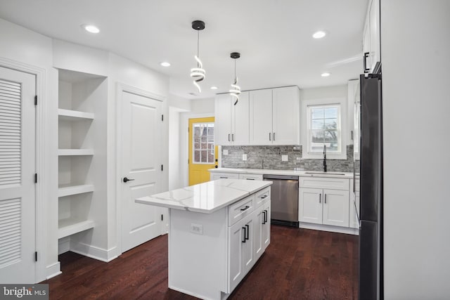 kitchen featuring stainless steel dishwasher, decorative light fixtures, a kitchen island, and white cabinets