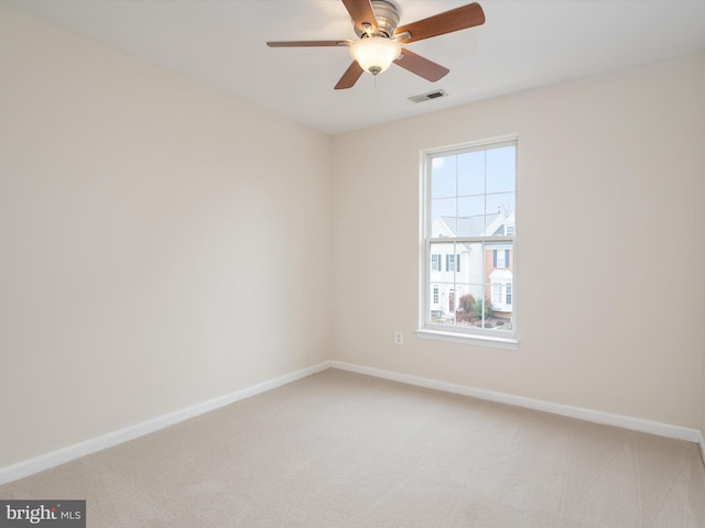 carpeted spare room featuring ceiling fan