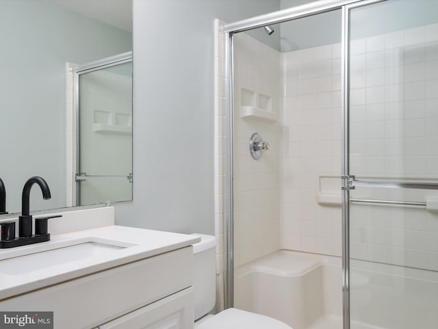 bathroom featuring vanity, toilet, and an enclosed shower