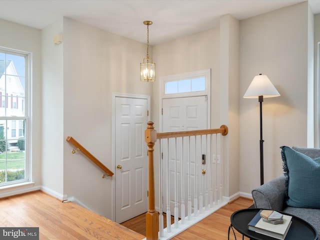 foyer entrance featuring an inviting chandelier and wood-type flooring