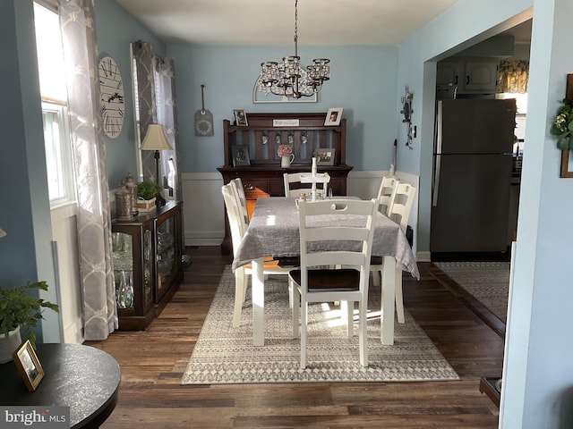 dining space featuring dark wood-type flooring and a chandelier