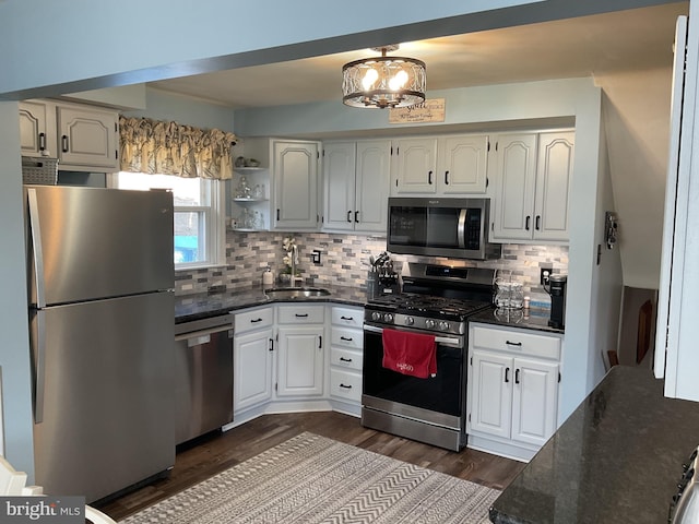 kitchen with backsplash, stainless steel appliances, sink, and white cabinets