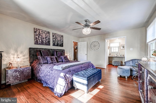 bedroom with connected bathroom, hardwood / wood-style flooring, and ceiling fan