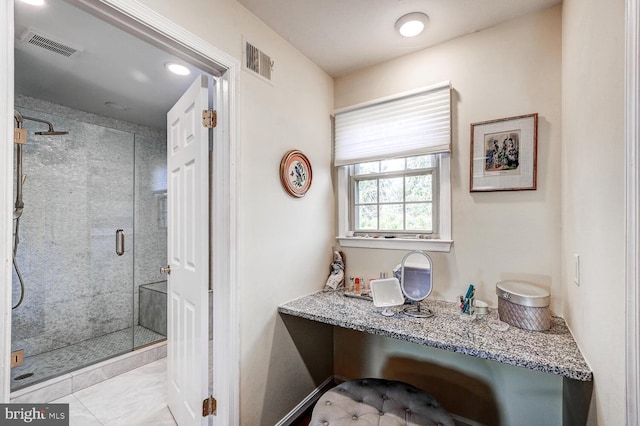 bathroom with an enclosed shower and tile patterned floors