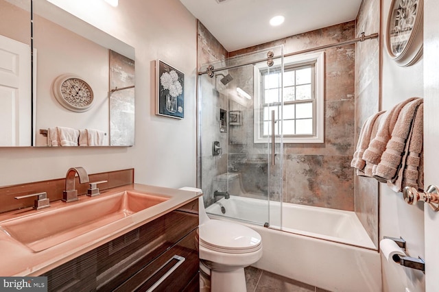 full bathroom with toilet, tile patterned floors, vanity, and bath / shower combo with glass door