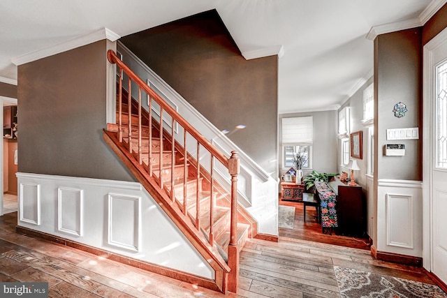 staircase with hardwood / wood-style flooring and crown molding