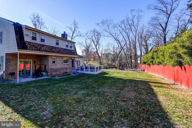 view of yard featuring a playground, a patio, and french doors