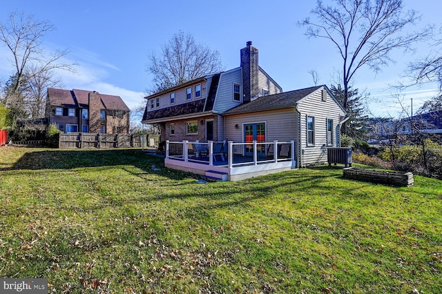 back of property with a wooden deck and a yard