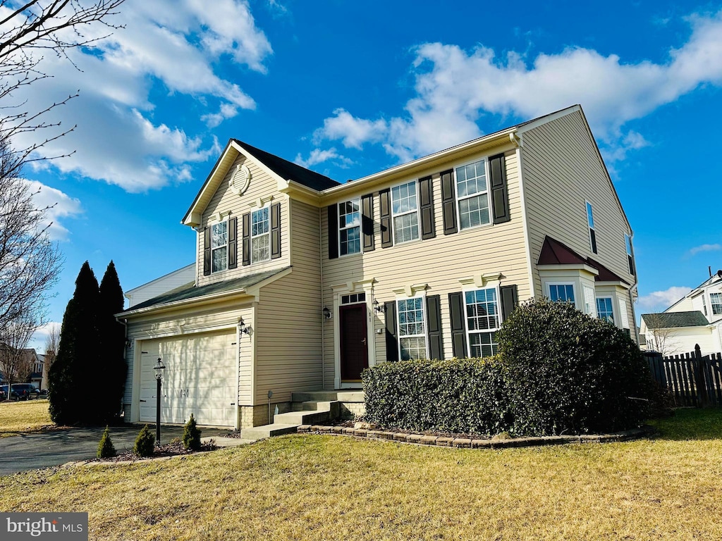 view of front of property featuring a garage and a front lawn