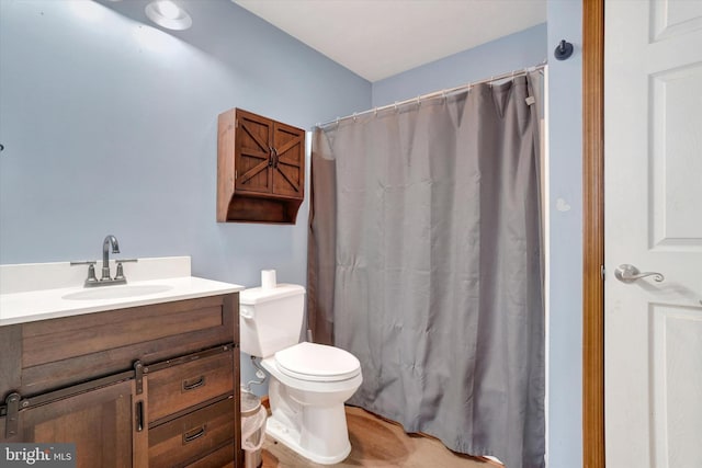 bathroom featuring walk in shower, vanity, and toilet