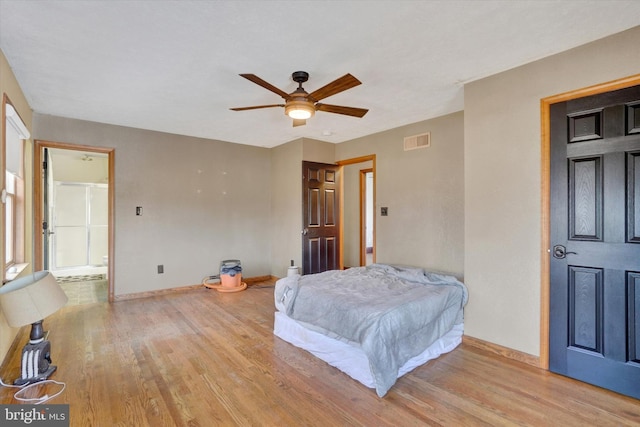 bedroom featuring connected bathroom, ceiling fan, and light wood-type flooring