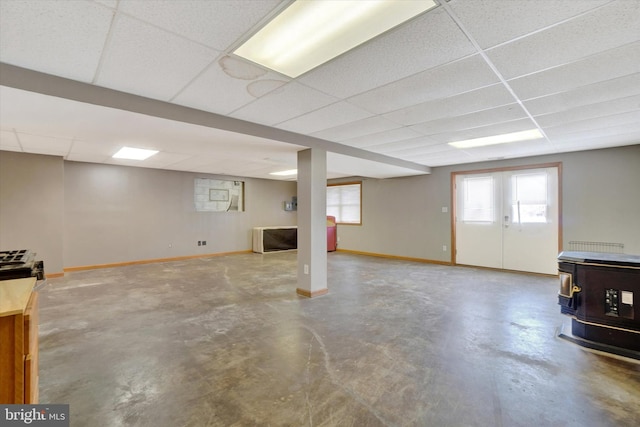 basement featuring french doors and a paneled ceiling