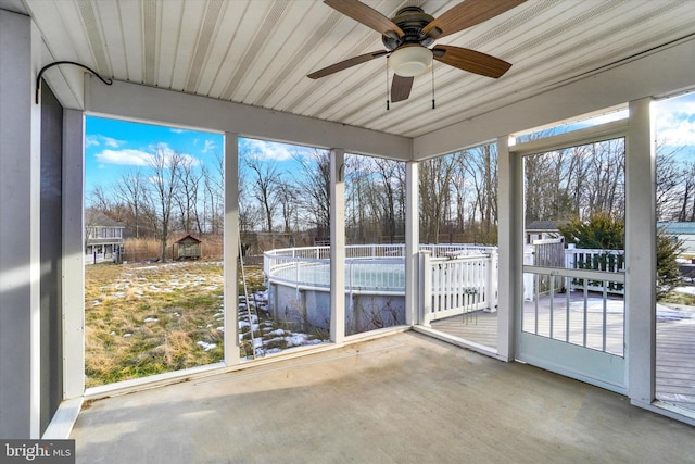 unfurnished sunroom with ceiling fan