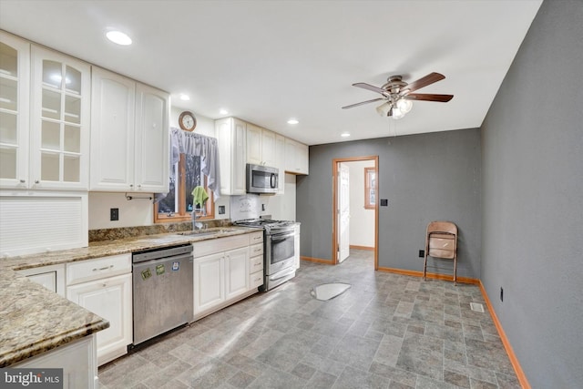 kitchen featuring sink, white cabinetry, ceiling fan, stainless steel appliances, and light stone countertops