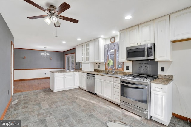 kitchen featuring appliances with stainless steel finishes, pendant lighting, sink, white cabinets, and kitchen peninsula