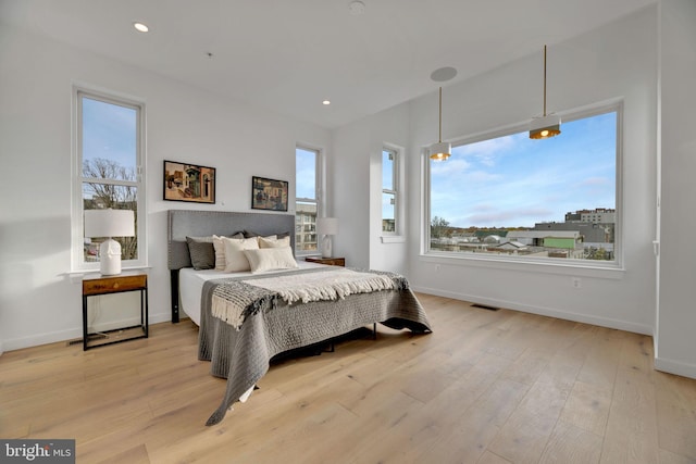 bedroom featuring multiple windows and light hardwood / wood-style flooring