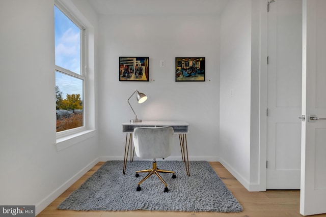 home office with light hardwood / wood-style floors