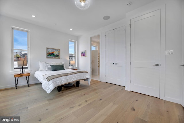 bedroom with multiple windows and light hardwood / wood-style flooring