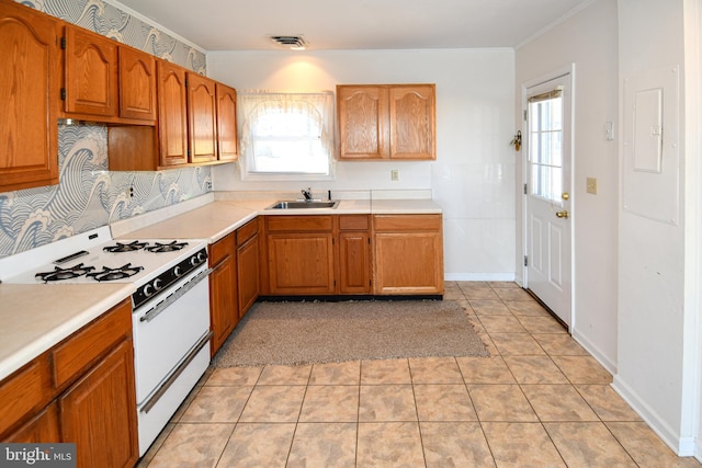 kitchen with sink, light tile patterned floors, electric panel, white gas range oven, and crown molding