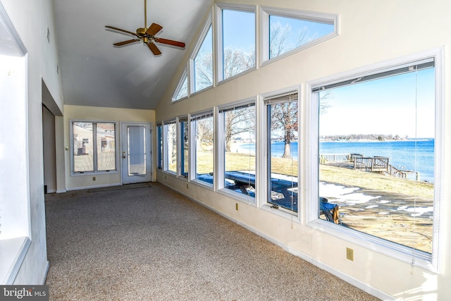 unfurnished sunroom featuring vaulted ceiling, ceiling fan, and a water view