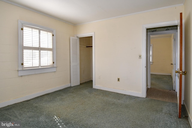 unfurnished bedroom featuring crown molding, a closet, and dark colored carpet