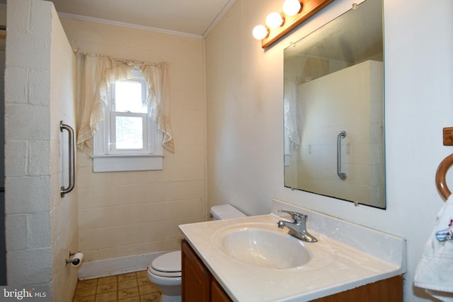 bathroom with vanity, crown molding, and toilet