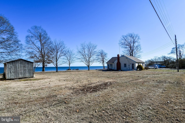 view of yard with a water view and a shed