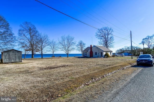 view of yard featuring a shed and a water view