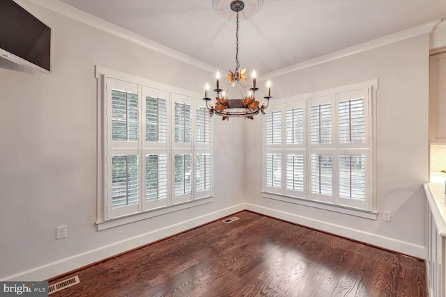 unfurnished dining area with hardwood / wood-style flooring, ornamental molding, and a chandelier