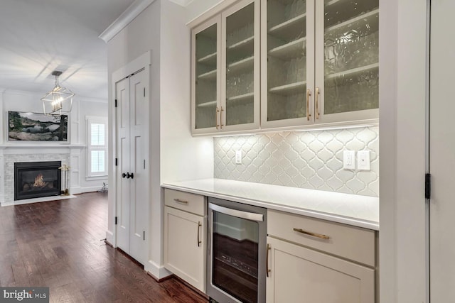 kitchen featuring crown molding, hanging light fixtures, tasteful backsplash, dark hardwood / wood-style flooring, and beverage cooler