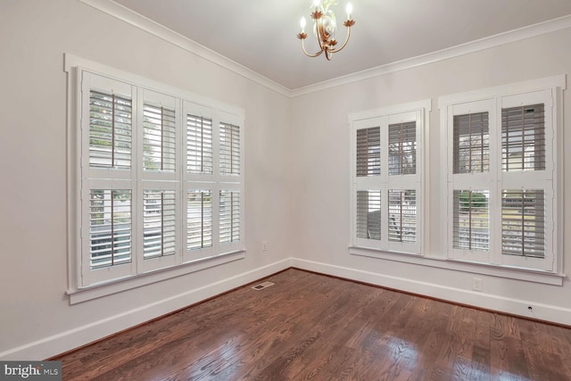 unfurnished room with ornamental molding, dark hardwood / wood-style floors, and a chandelier