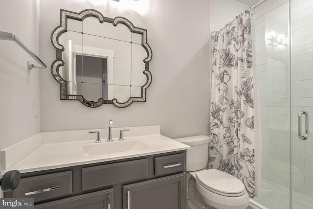 bathroom featuring vanity, toilet, and walk in shower