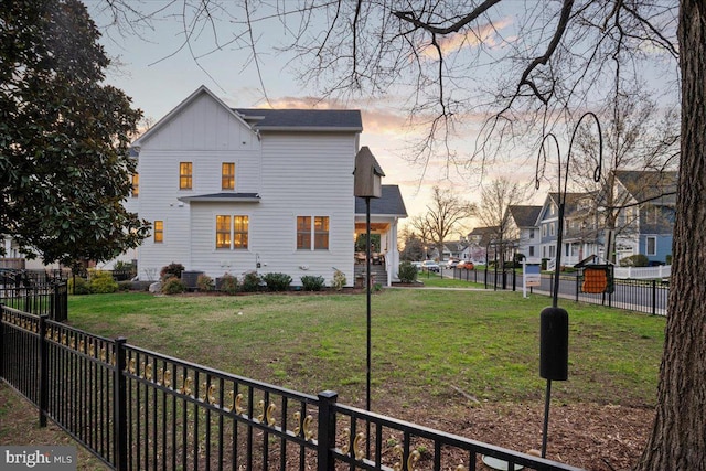 property exterior at dusk featuring a lawn