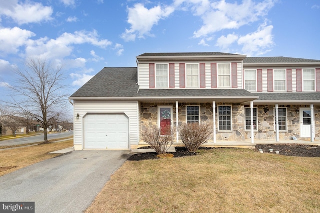 view of front facade featuring a garage, a front yard, and covered porch