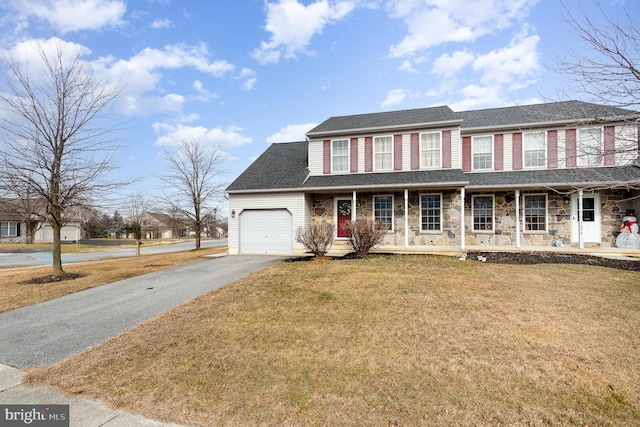 view of front of home with a garage, covered porch, and a front lawn