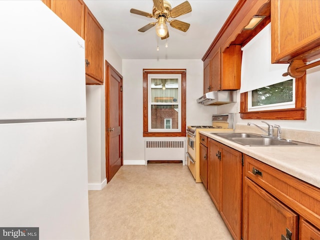 kitchen with sink, stainless steel range with gas cooktop, radiator, white fridge, and ceiling fan