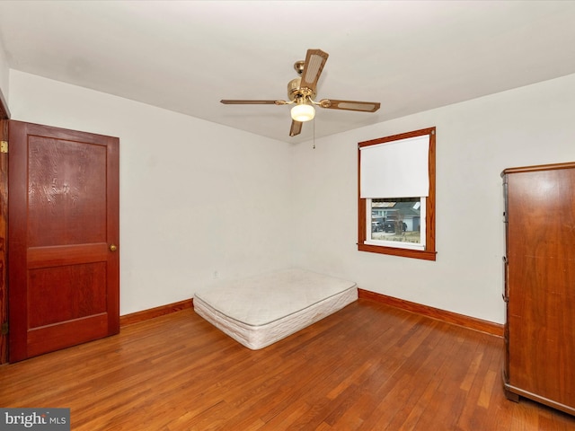 unfurnished bedroom with ceiling fan and hardwood / wood-style floors