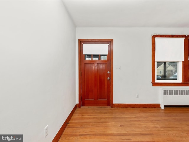 entryway with radiator heating unit and light hardwood / wood-style flooring